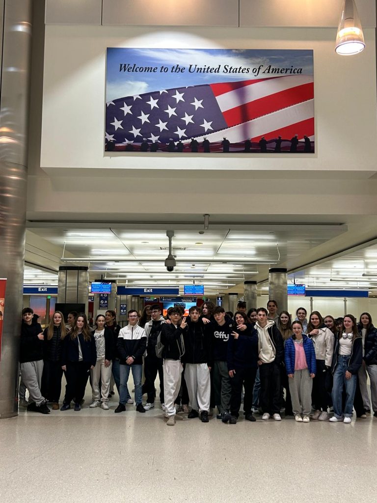 Arrivée à l'aéroport de Los Angeles, le groupe sous le drapeau américain